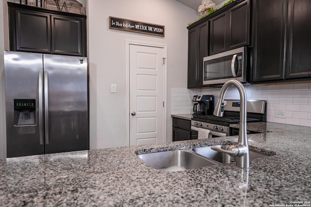 kitchen featuring decorative backsplash, stone counters, and appliances with stainless steel finishes