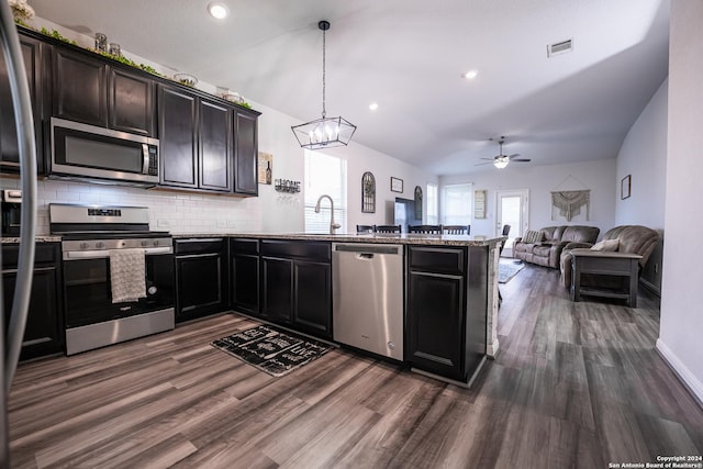 kitchen featuring ceiling fan with notable chandelier, stainless steel appliances, a peninsula, dark wood-type flooring, and visible vents