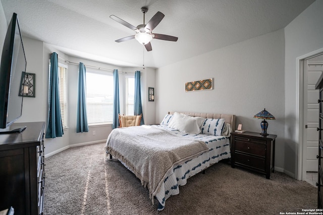 bedroom with baseboards, carpet flooring, a textured ceiling, and a ceiling fan