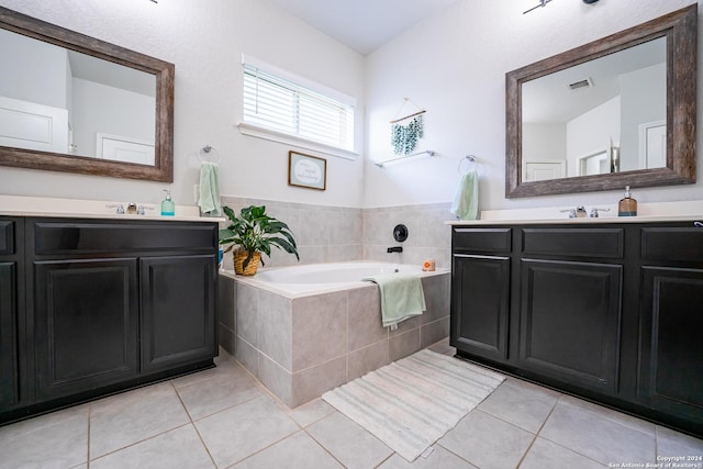 bathroom with tile patterned floors, visible vents, a bath, and two vanities