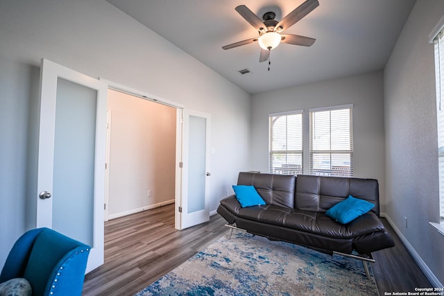 living area with baseboards, a ceiling fan, wood finished floors, and visible vents