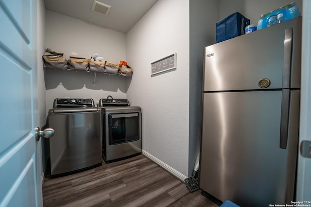 washroom featuring laundry area, baseboards, visible vents, dark wood-style floors, and washer and clothes dryer