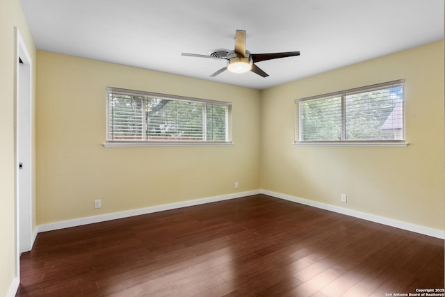 unfurnished bedroom with baseboards, multiple windows, and dark wood finished floors
