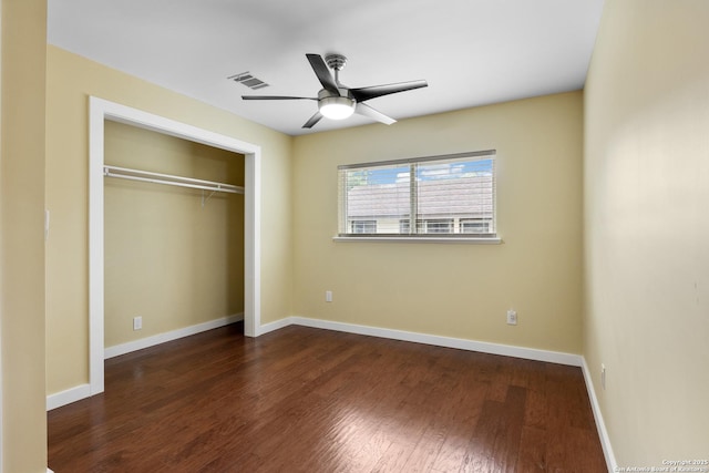 unfurnished bedroom featuring baseboards, a closet, wood finished floors, and visible vents