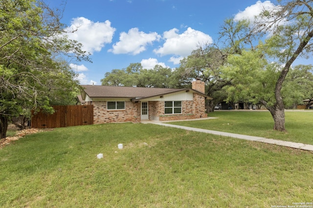 ranch-style home with fence, a chimney, a front lawn, and brick siding