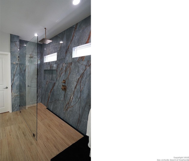 bathroom featuring a marble finish shower, recessed lighting, and wood finished floors