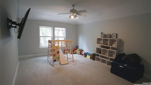 playroom featuring carpet floors, a ceiling fan, and baseboards