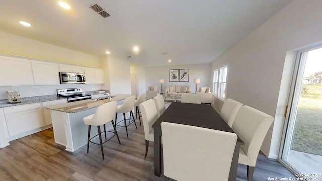 dining room featuring visible vents, recessed lighting, and wood finished floors