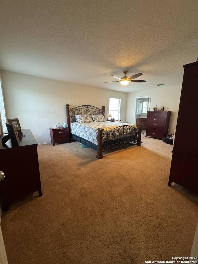 carpeted bedroom with a textured ceiling and ceiling fan