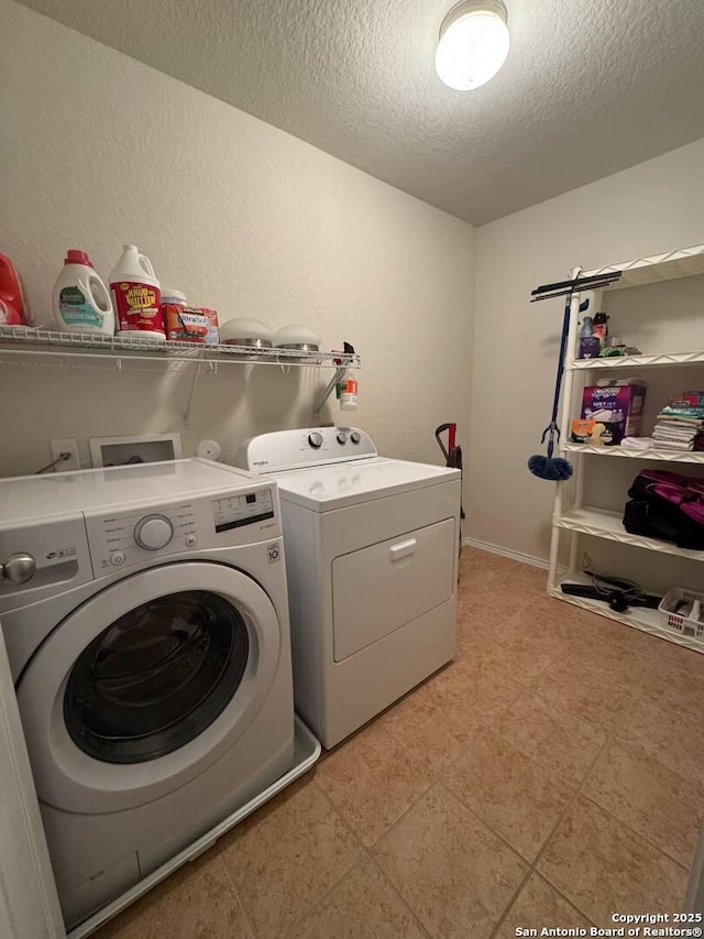 laundry area featuring laundry area, a textured ceiling, and washer and dryer
