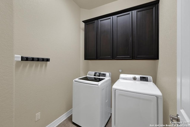 laundry room featuring cabinet space, baseboards, and washing machine and dryer