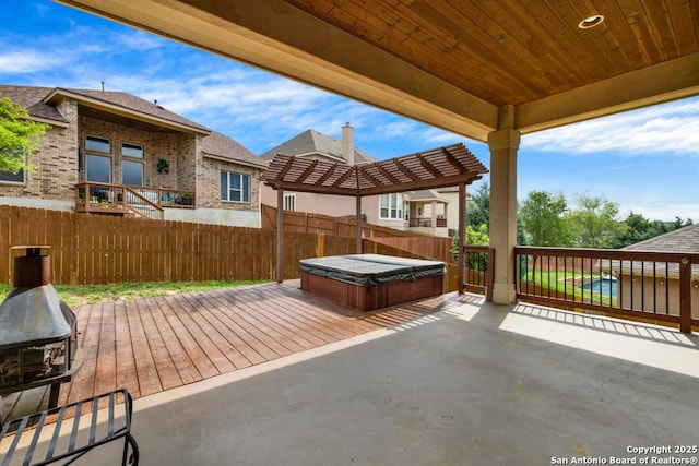 view of patio / terrace with fence, a covered hot tub, and a deck
