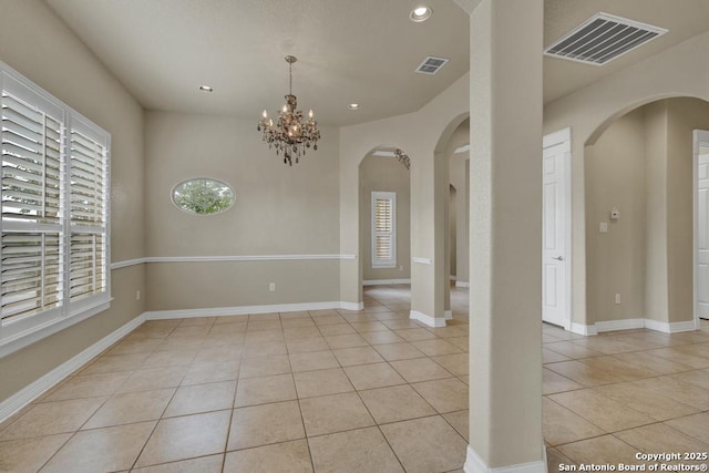 spare room with arched walkways, visible vents, light tile patterned floors, and recessed lighting