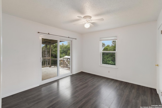 unfurnished room with a ceiling fan, a textured ceiling, dark wood finished floors, and baseboards
