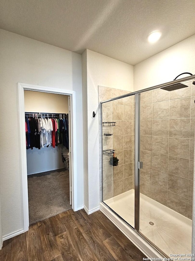 1238 Yellow Warbler Run, San Antonio, TX 78253 - full bath featuring wood finished floors, a stall shower, a textured ceiling, and a spacious closet