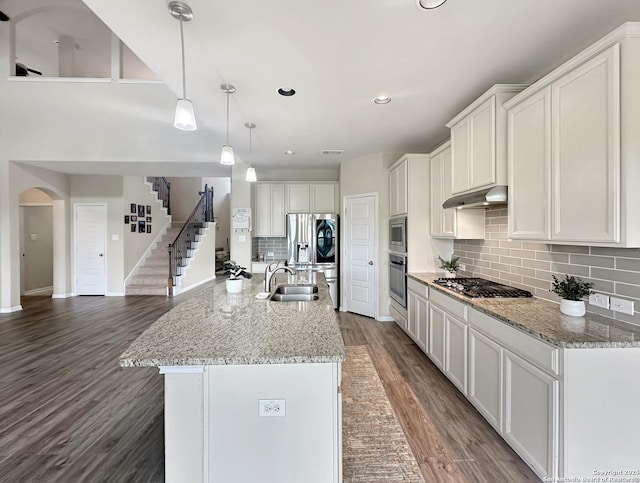 104 Talavera, Boerne, TX 78006 - kitchen with appliances with stainless steel finishes, under cabinet range hood, a sink, arched walkways, and wood finished floors