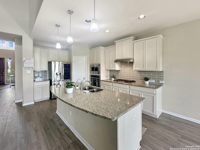 104 Talavera, Boerne, TX 78006 - kitchen featuring appliances with stainless steel finishes, a sink, under cabinet range hood, a kitchen island with sink, and tasteful backsplash