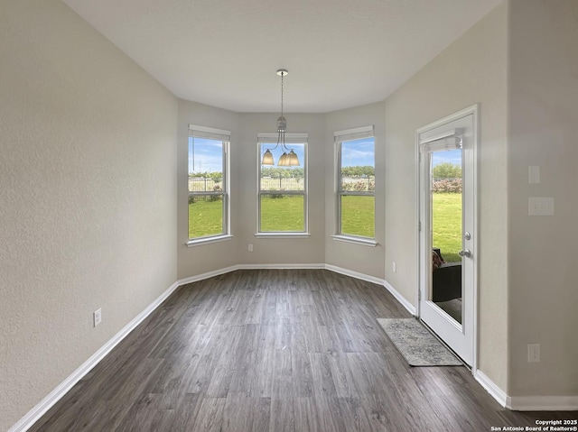104 Talavera, Boerne, TX 78006 - unfurnished dining area featuring dark wood-style flooring, baseboards, and a textured wall