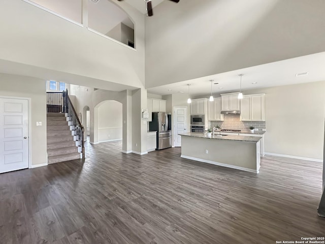 104 Talavera, Boerne, TX 78006 - kitchen with appliances with stainless steel finishes, arched walkways, dark wood-style floors, white cabinetry, and baseboards
