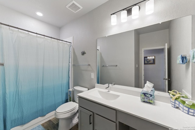 bathroom featuring visible vents, shower / bath combo, wood finished floors, vanity, and toilet