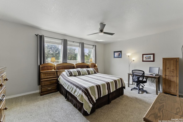 bedroom featuring a ceiling fan, a textured ceiling, light carpet, and baseboards