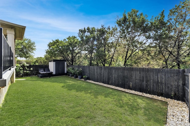 view of yard featuring a fenced backyard, an outbuilding, and a shed