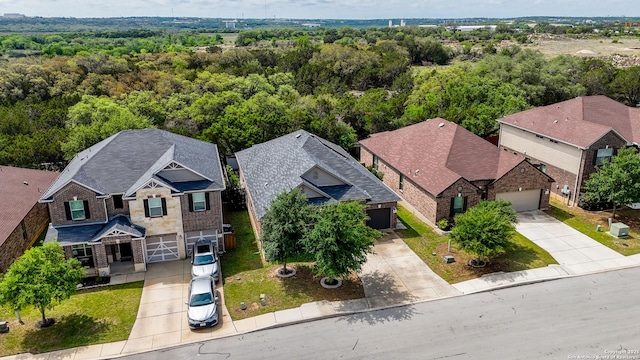 drone / aerial view featuring a residential view and a forest view