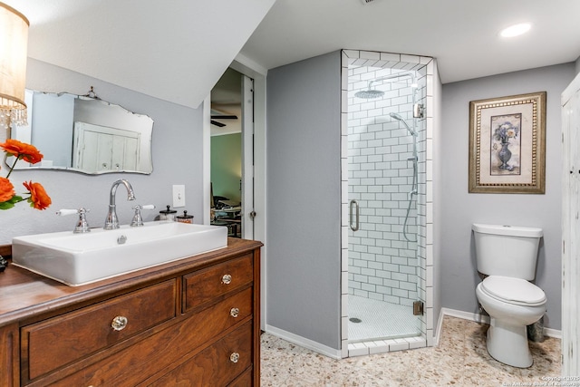 full bath featuring vanity, toilet, baseboards, a ceiling fan, and a stall shower