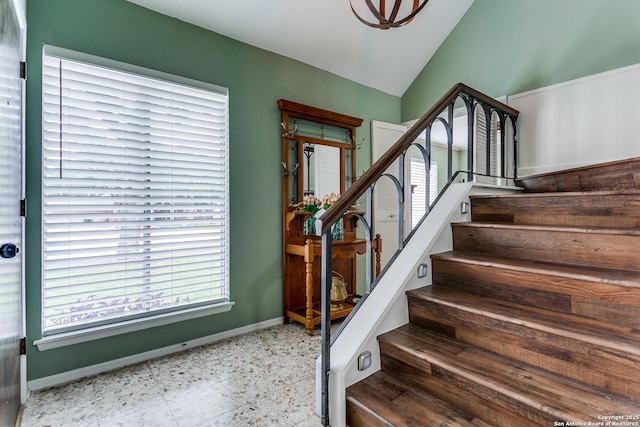 staircase with baseboards and lofted ceiling