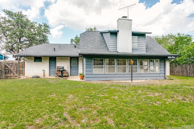 rear view of property featuring a lawn, a chimney, and a fenced backyard
