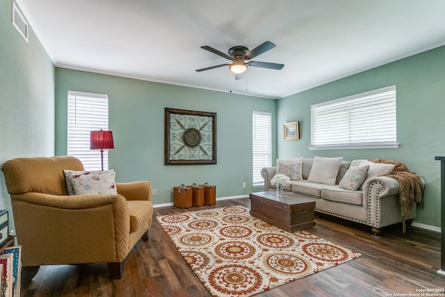 living room with a ceiling fan, baseboards, visible vents, and wood finished floors