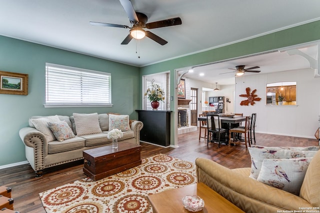 living room featuring a ceiling fan, baseboards, plenty of natural light, and wood finished floors