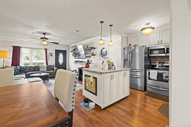 6377 County Road 659, Brazoria, TX 77422 - kitchen with visible vents, light wood-style flooring, white cabinetry, and stainless steel appliances