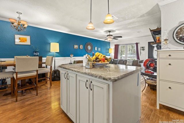 6377 County Road 659, Brazoria, TX 77422 - kitchen featuring crown molding, a textured ceiling, light wood finished floors, and ceiling fan with notable chandelier