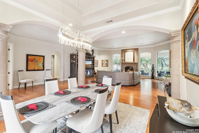 dining space featuring arched walkways, recessed lighting, light wood-type flooring, visible vents, and ornamental molding