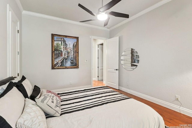 bedroom with baseboards, ornamental molding, a ceiling fan, and wood finished floors