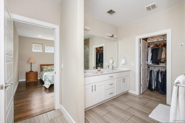 440 E Olmos, San Antonio, TX 78212 - ensuite bathroom featuring double vanity, wood finished floors, baseboards, and a spacious closet