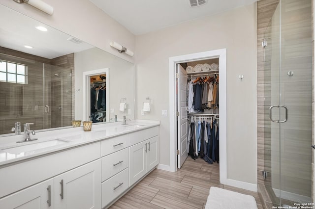 440 E Olmos, San Antonio, TX 78212 - bathroom with a stall shower, double vanity, baseboards, a spacious closet, and recessed lighting