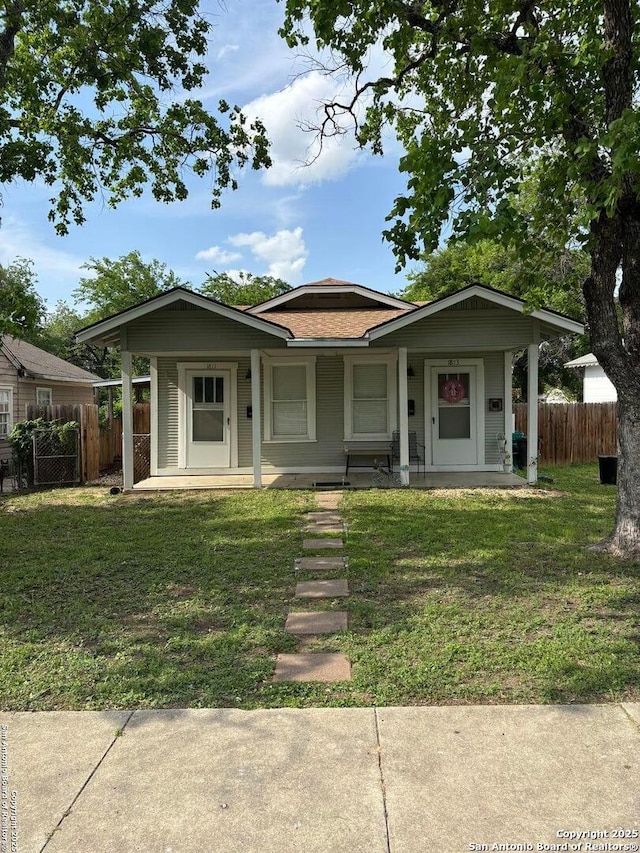 bungalow featuring fence, a porch, and a front lawn
