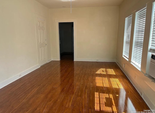unfurnished room featuring baseboards and wood finished floors