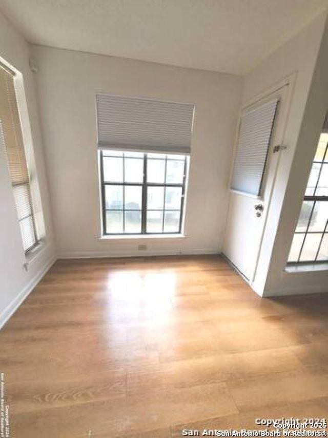 unfurnished room with light wood-style floors and baseboards