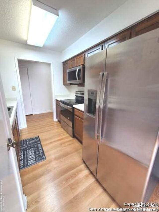 kitchen featuring light countertops, appliances with stainless steel finishes, and light wood-style flooring