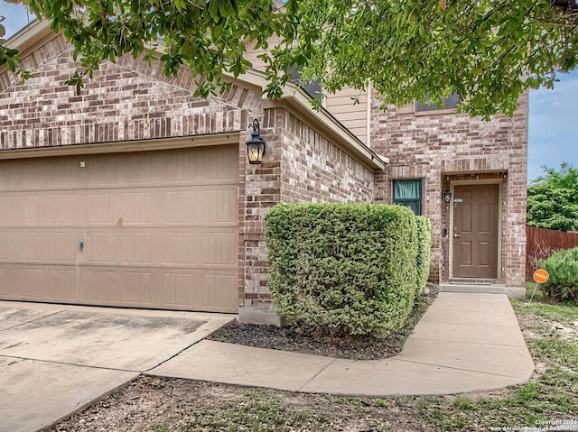 view of front of house with brick siding, an attached garage, and driveway