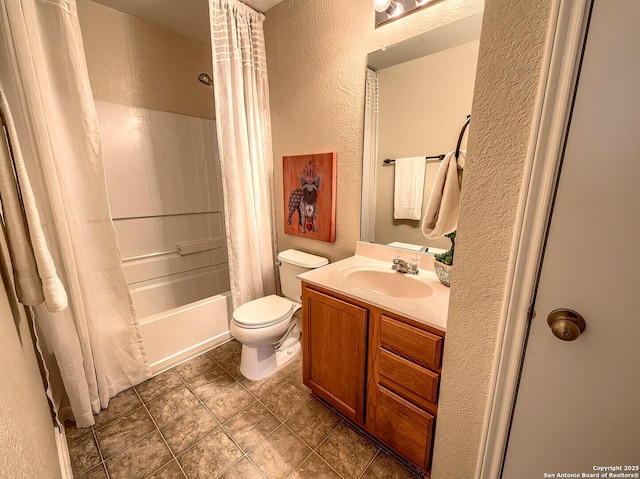full bath featuring vanity, tile patterned flooring, a textured wall, toilet, and shower / bath combo