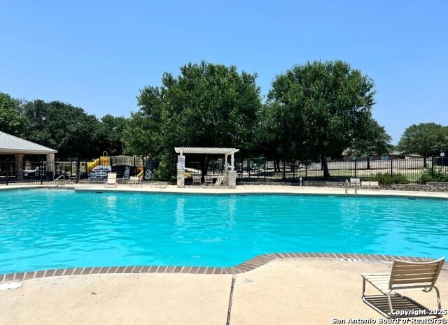 community pool featuring a patio, fence, and a pergola