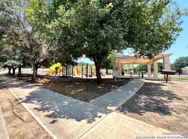 view of community featuring a gazebo, fence, and playground community