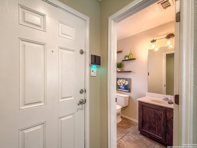 interior space with light tile patterned floors, baseboards, visible vents, and a sink