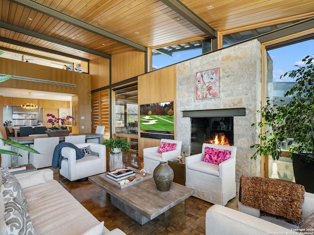 living room featuring beam ceiling, a notable chandelier, and a fireplace
