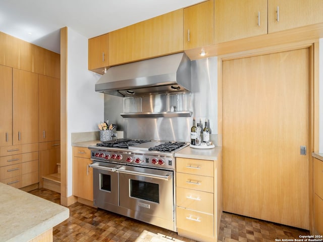 kitchen with light countertops, light brown cabinetry, exhaust hood, and double oven range