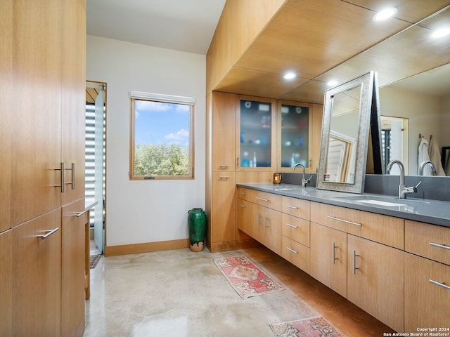 full bathroom featuring double vanity, a sink, baseboards, concrete floors, and recessed lighting